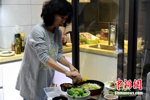 图为李妈妈在制作料理。 吕明 摄