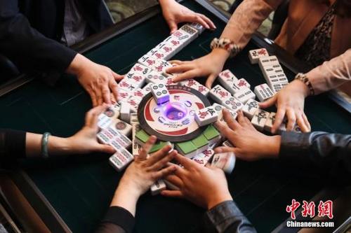 中国侨网资料图，巴蜀很多餐馆都提供麻将机，聚餐过后大家不打上几盘麻将是不愿离开的。在达州一餐馆内正在打麻将的人们。中新社发 熊然 摄