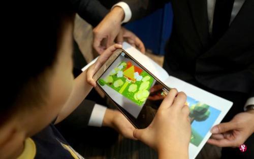 中国侨网一名幼儿在使用这本童话故事书。（新加坡《联合早报》/严宣融 摄）