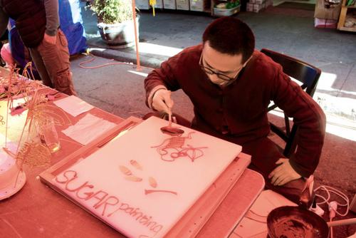 中国侨网“糖画”师傅现场作画，一分钟就画好了。（美国《世界日报》／李晗 摄影）