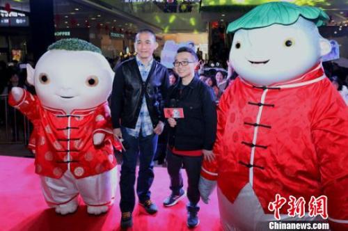 《捉妖记2》主演梁朝伟、导演许诚毅与粉丝们合影。　泱波 摄