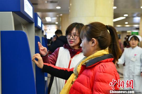吉林大学中日联谊医院工作人员指导民众如何使用自助挂号、缴费终端。吉林省卫计委供图