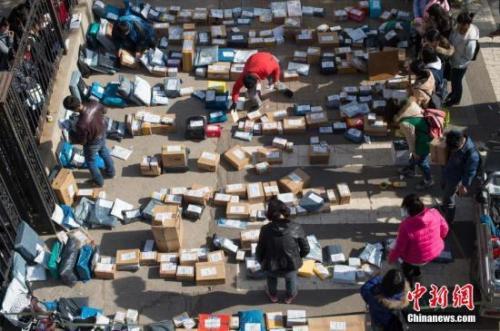 2016年“双11”后各地迎来快递派送高峰。图为工作人员忙着分拣满地的快递。武俊杰 摄
