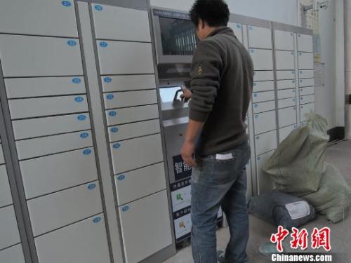 资料图：快递员使用智能快递柜投送包裹。韩章云 摄