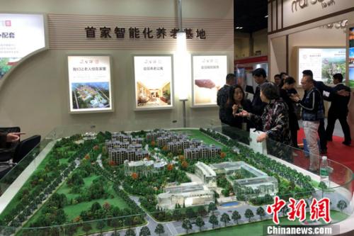 2018北京春季房展会上某养老地产项目的工作人员在向观众进行介绍。程春雨 摄