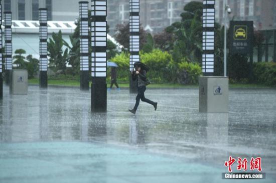 资料图:民众在雨中出行。 陈超 摄 点击进入下一页