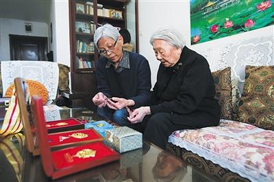 周智夫二女儿周卫平和母亲娄淑珍静静地端详着周智夫生前所获勋章。