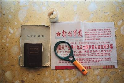 周智夫生前看的报纸、使用的放大镜、字典和笔记本。