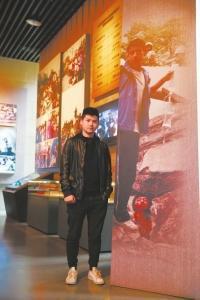 “吊瓶男孩”李阳站在十年前的照片前。