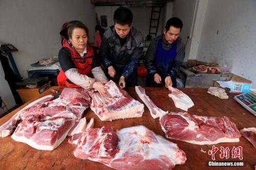 居民在家中切猪肉。谭凯兴 摄