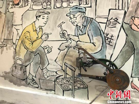 在墙外放着修鞋机实物，让连环画更显鲜活?！⊥踝犹?摄