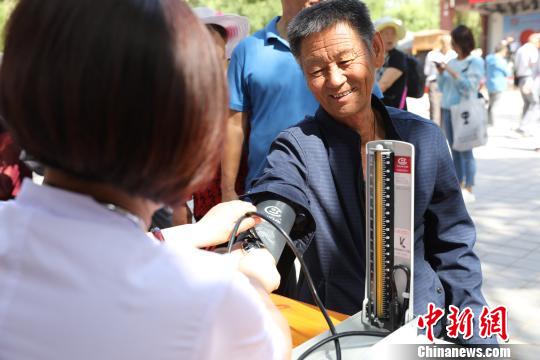 义诊医生在为市民测量血压?！『?摄