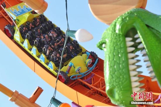 4月26日，上海迪士尼度假区迎来了乐园的第七个主题园区“迪士尼·皮克斯玩具总动员”主题园区全新开幕。据了解，新园区包括三个全新的景点——弹簧狗团团转、抱抱龙冲天赛车和胡迪牛仔嘉年华，一个独特的与迪士尼朋友见面的主题区域——友情驿站，以及提供沉浸式购物和餐饮体验的艾尔玩具店和玩具盒欢宴广场。图为游客在园区内游玩。<a target='_blank' href='http://www.chinanews.com/'>中新社</a>记者 张亨伟 摄
