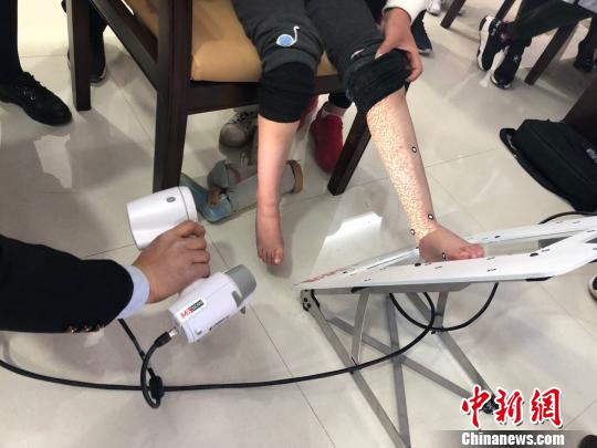 图为技师使用红外激光扫描取样。(资料图) 徐雪 摄