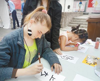 中国侨网6月10日，为期4天的第三届比利时列日省“中国城会”活动落下帷幕。图为列日大学的学生在活动现场学习书法。 本报记者 任 彦摄 