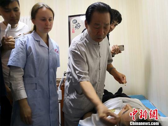 图为甘肃岐黄国医馆负责人何天有现场向国外中医爱好者教学“针灸”。　魏建军 摄