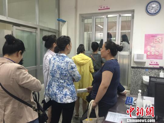 图为等候接种HPV疫苗的民众?！⊙爰ё柯?摄