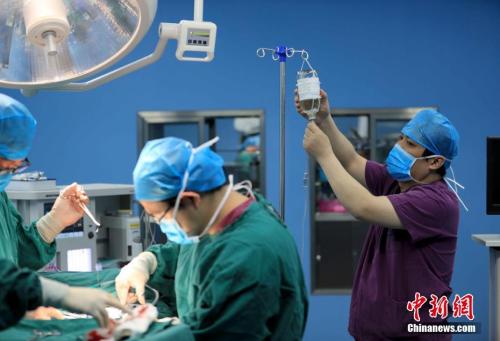 资料图:手术室护士在协助医生手术。 沈果 摄 点击进入下一页