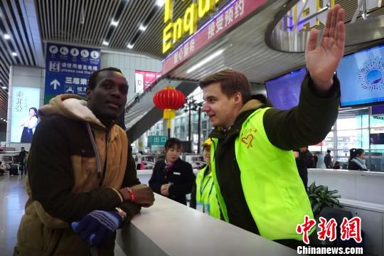 华南理工大学留学生参与2018年春运志愿者服务。资料图?！∈芊谜吖┩?摄