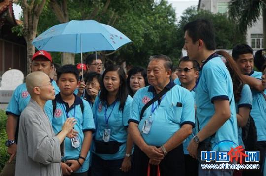 华裔青少年聆听龙华寺住持讲解?！±钛┯?摄