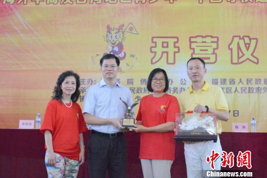 中国侨网7月9日，2018年海外华裔及台湾地区青少年“中国寻根之旅”夏令营——福建洛江营开营式上，主办方互赠纪念品?！∷锖纭∩? style=