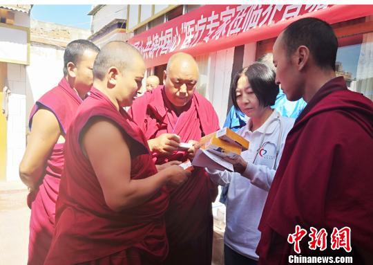 图为专家为僧人叮嘱服药注意事项。　南如卓玛 摄