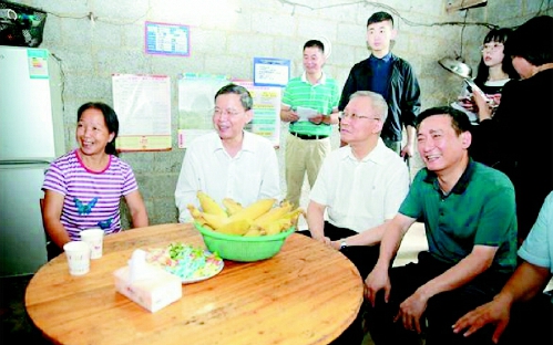 ▲调研组走进靖西市龙邦镇大莫村村民家中座谈交流，了解贫困户吕母千通过开办家庭酒坊，每月增收一千多元的脱贫经验。