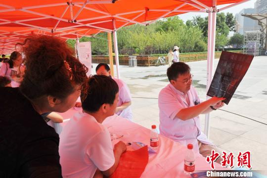 图为医学专家为患者讲解病情?！≈旖ň?摄