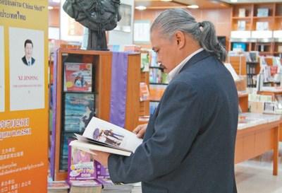 中国侨网“中国书架”旁，一名当地读者正在认真阅读中文书籍。 本报记者 张志文摄   