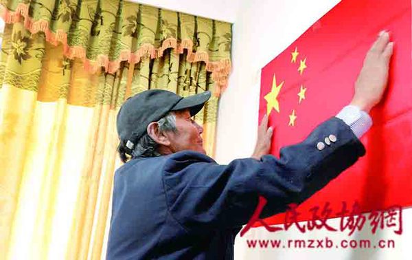 旺扎在客厅墙上醒目的位置挂了一面五星红旗