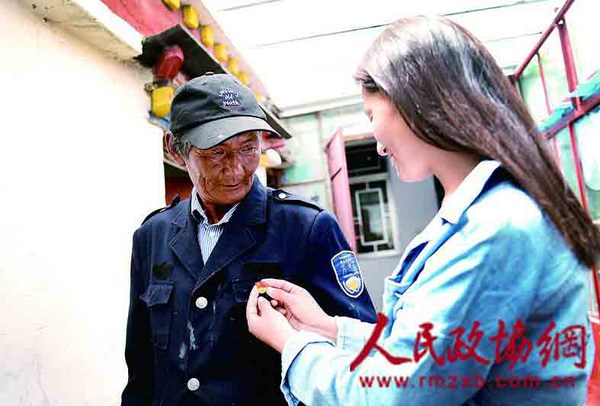 旺扎是多年的老党员，女儿阿旺卓玛为他佩戴党徽.jpg(1)