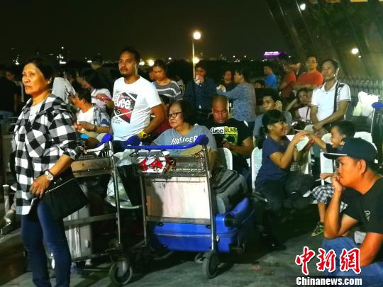 候机厅外不少滞留旅客将行李放在手推车上，靠着休息?！」叵蚨?摄