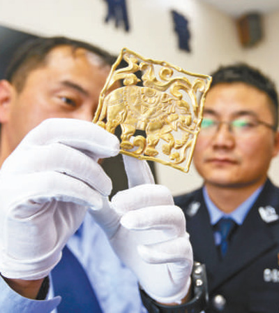 图为公安人员在展示追缴回的文物 图为公安人员在展示追缴回的文物