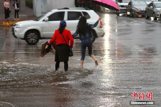 资料图:民众在降雨中出行。 <a target='_blank' href='http://www.chinanews.com/'>中新社</a>记者 李培源 摄 点击进入下一页