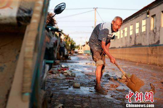 8月24日，洪水退去后潍坊寿光政府组织人员清理街道。潍坊市已启动《重大自然灾害卫生应急预案》最高级别响应。据统计，潍坊市已修复县乡路路基、路面79.14公里，?局部损毁桥涵11座；抢通县乡公路22条、143公里?！×籂?摄