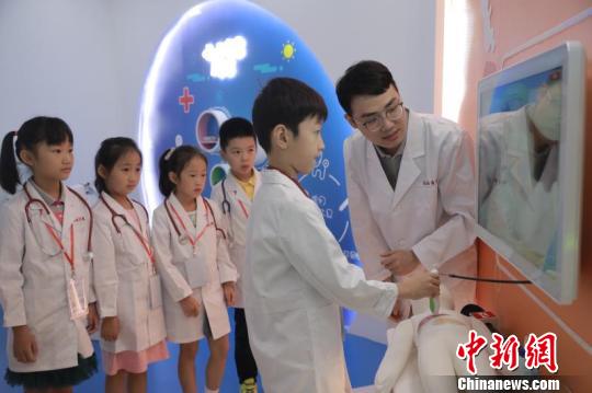 首批14名小体验者走进梦想医学院，穿上定制的白大褂，变身“见习小医生”?！≤缝?摄