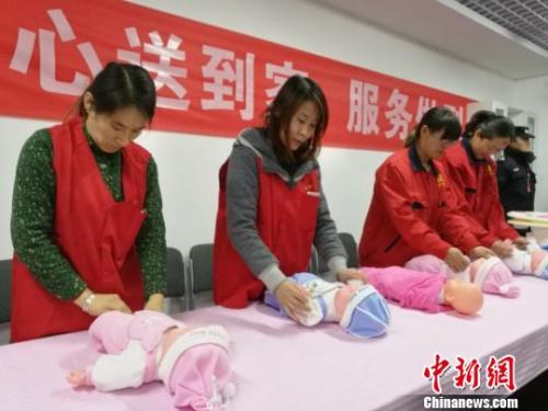 图为护工练习护理婴儿。 李娜 摄 点击进入下一页