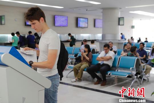 外籍人士正在上海市公安局出入境管理局内办理相关业务?！∫罅⑶?摄