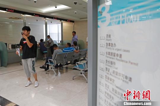 上海市公安局出入境管理局内，民众正在咨询和办理相关业务?！∫罅⑶?摄