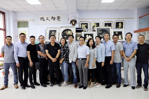 图为：锡林格勒盟盟委委员、行署副盟长曲卫国、人民政协网总经理付鹏、北京时间联席总裁陈朝华、人民网共产党新闻网副总编辑姚奕等媒体领导与麦秸画创作者杨丽丽合影