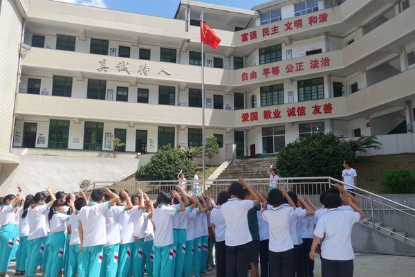 图2：开学第一天，岩山中学学生与岩山小学学生一起升国旗。