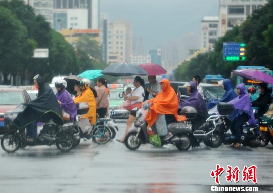 资料图:民众在雨中出行。张斌 摄 点击进入下一页