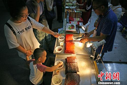 7月14日，市民在澳门展区品尝香记肉干?；盍Π拿磐乒阒茉?018天津“华博会”同期举办，展区设有210个展位，包含澳门风貌、澳门创意美食、时尚文创、家居用品等六大展区，让民众感受不一样的澳门风情。<a target='_blank' href='http://www.chinanews.com/'>中新社</a>记者 佟郁 摄