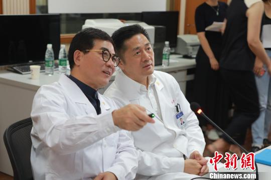 　院士们紧盯着屏幕，不时通过互联网远程视教系统，与主刀医师用简洁的专业术语进行沟通，不时提出指导意见?！≤缝?摄