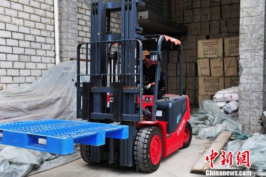 图为10月12日，西藏自治区民政厅救灾物资储备中心工人正在紧张地装载棉衣、棉被、棉褥、折叠床等救灾物资。　张伟 摄