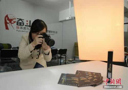 资料图:代购者在简易的摄影棚为代购的产品拍照。杨华峰 摄 点击进入下一页