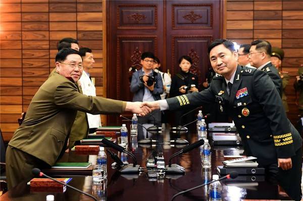 6月14日，在板门店朝方一侧“统一阁”，韩朝高级别军事会谈韩方代表团团长金度均（右）同朝方代表团团长安益山握手。新华社发（韩国国防部供图）