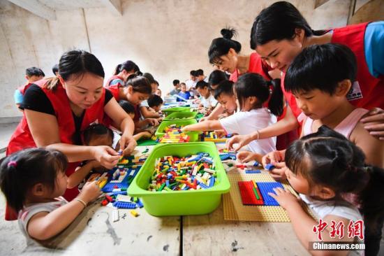 志愿者在与留守儿童一起搭积木、做游戏。 周亮 摄