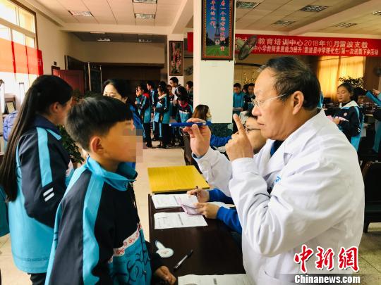 许海嘉在凉山筛查眼病患儿。　王鹏 摄