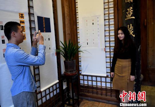 一名“90后”女大学生篆刻作者在自己创作的作品前留影?！〖钦吡蹩筛?摄